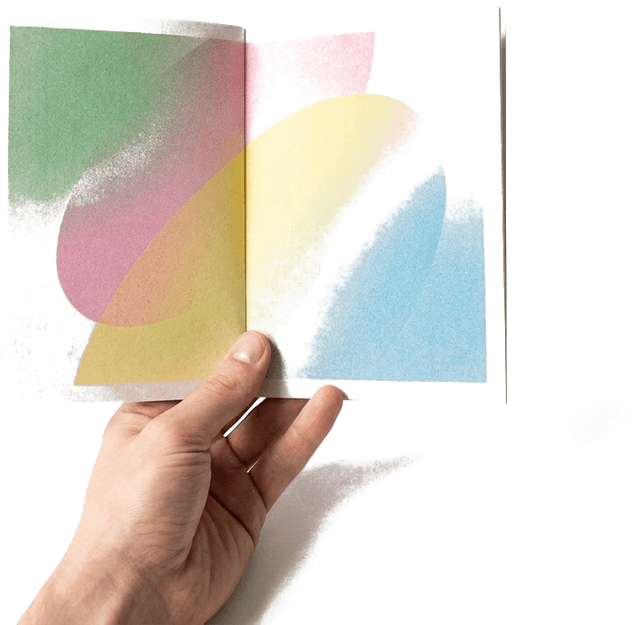 A hand holding an open booklet printed with pastel gradient shapes